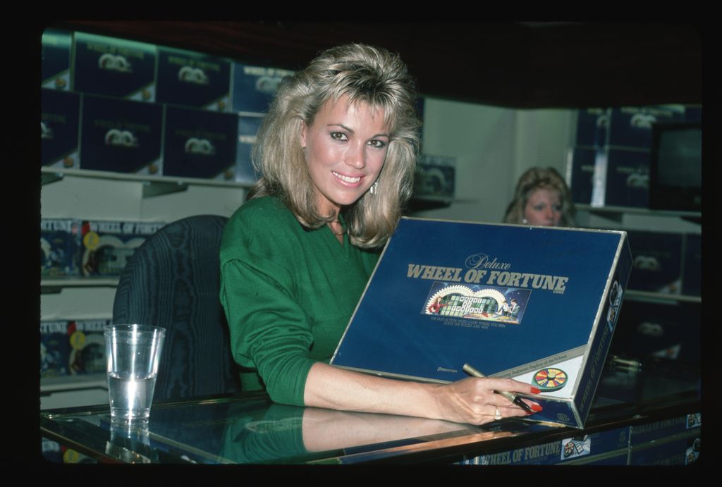 Vanna White signs copies of a Wheel of Fortune board game, 1986