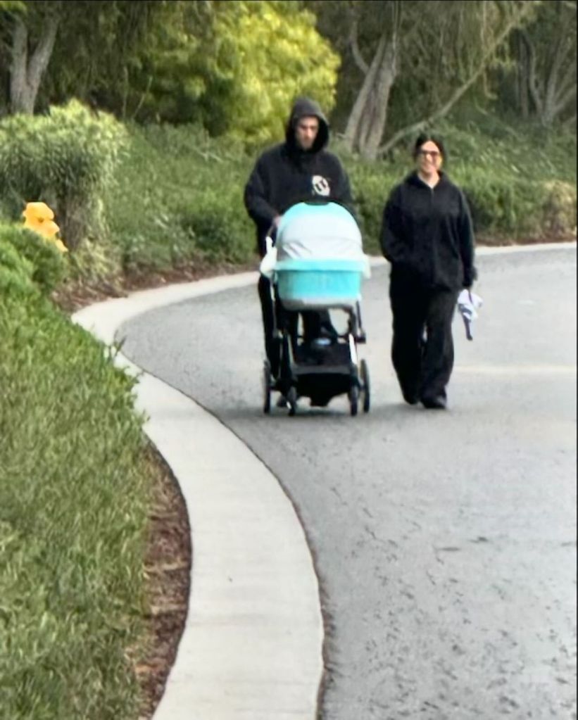 Kourtney and Travis walking baby Rocky in his pram