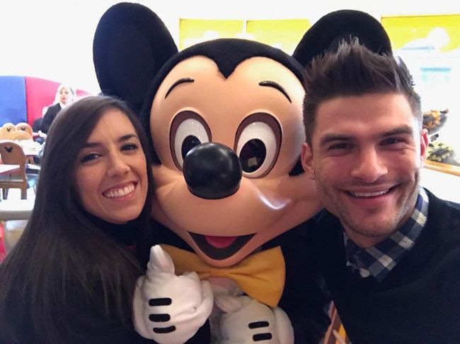 janette and aljaz smile and pose with a lifesize micky mouse
