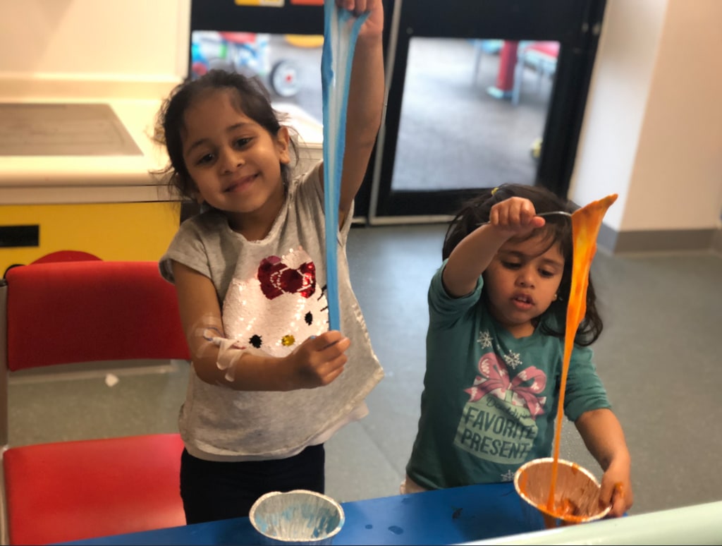 two young girls playing with slime