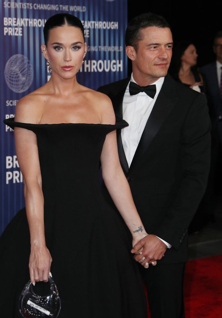 Katy Perry in an off-the-shoulder black dress and Orlando Bloom in a tux