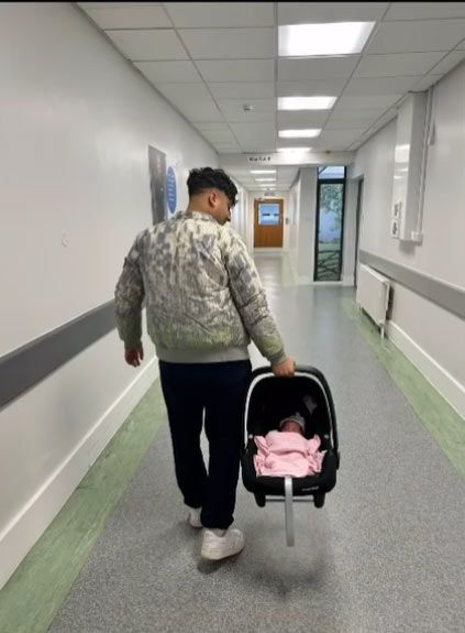 A photo of Karim Zeroual carrying his baby girl out of the hospital