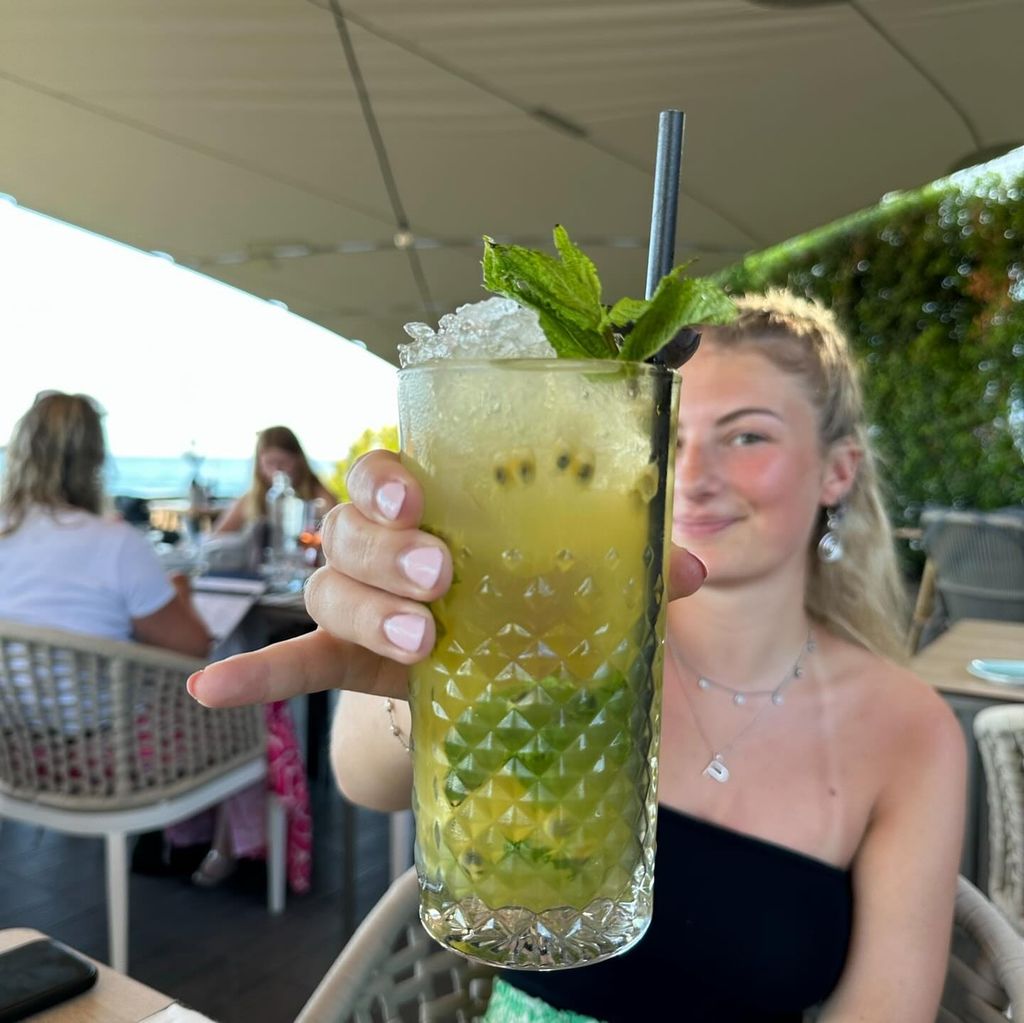 Poppy holding up a cocktail