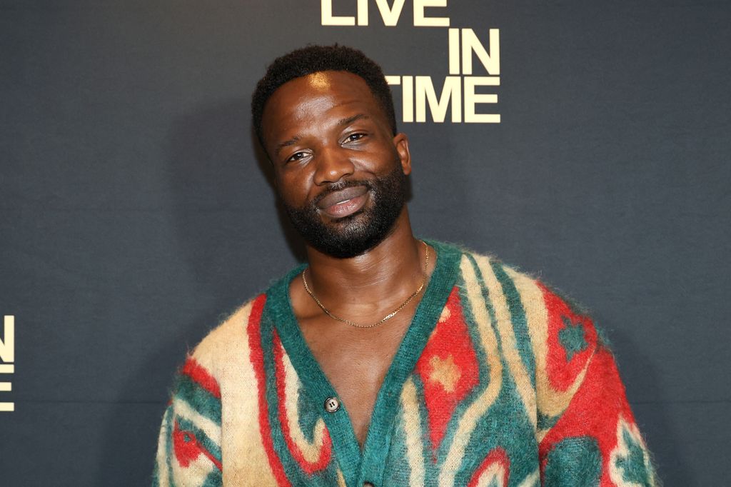 Ṣọpẹ́ Dìrísù posing in a colourful jumper