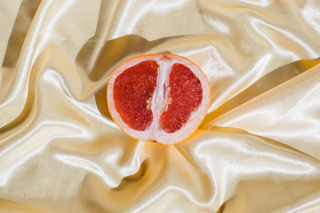 Fresh grapefruit on beige soft silk fabric background