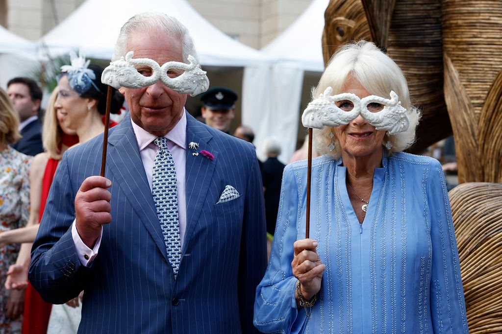 Britain's King Charles III and Britain's Queen Camilla hold masks as they attend the Animal Ball at Lancaster House in London 