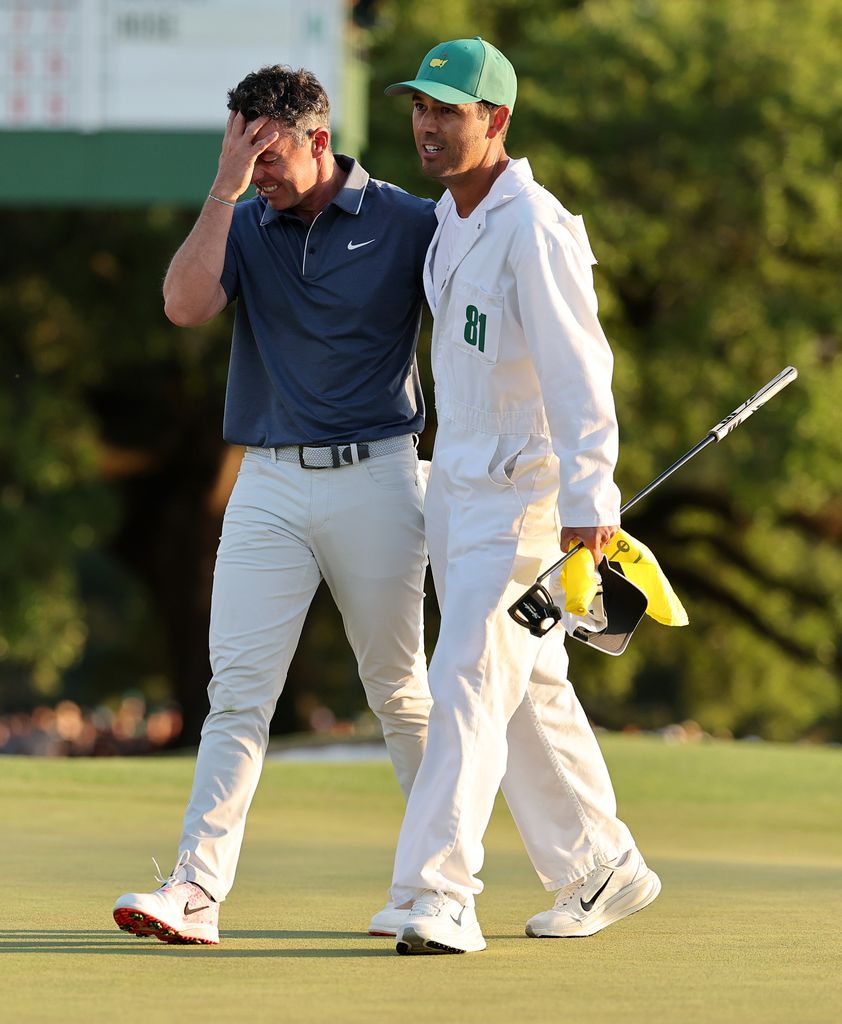 (L-R) Rory McIlroy of Northern Ireland celebrates winning with caddie Harry Diamond after the playoff hole