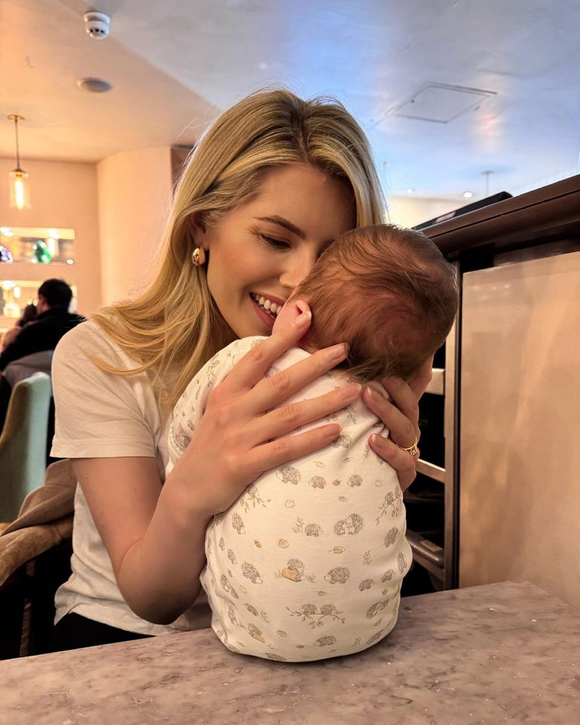 Mollie holding baby on table