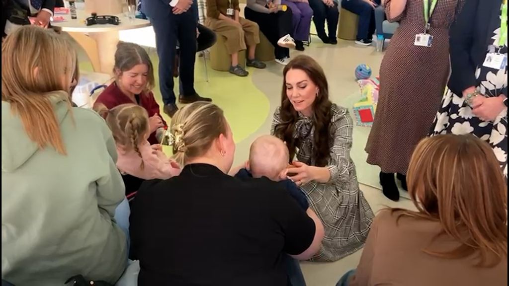 Kate wearing checked dress and talking to baby