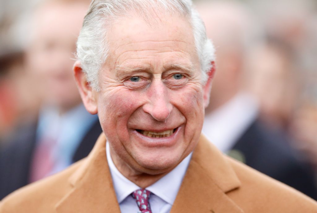 king charles smiling in camel coat