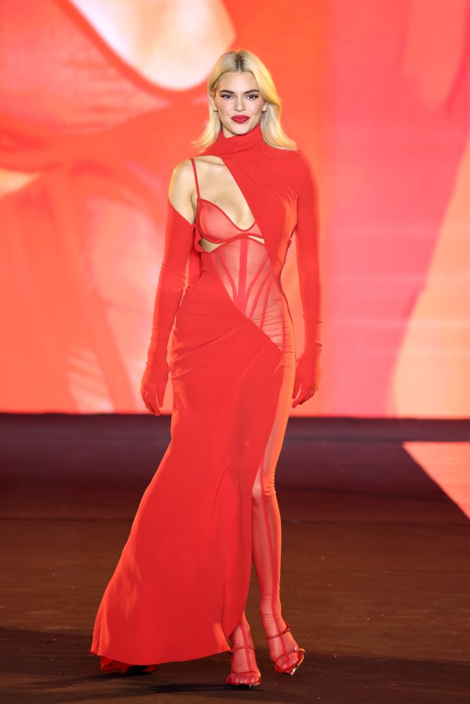 Kendall Jenner wearing a red mesh dress during the L'Oreal show at PFW