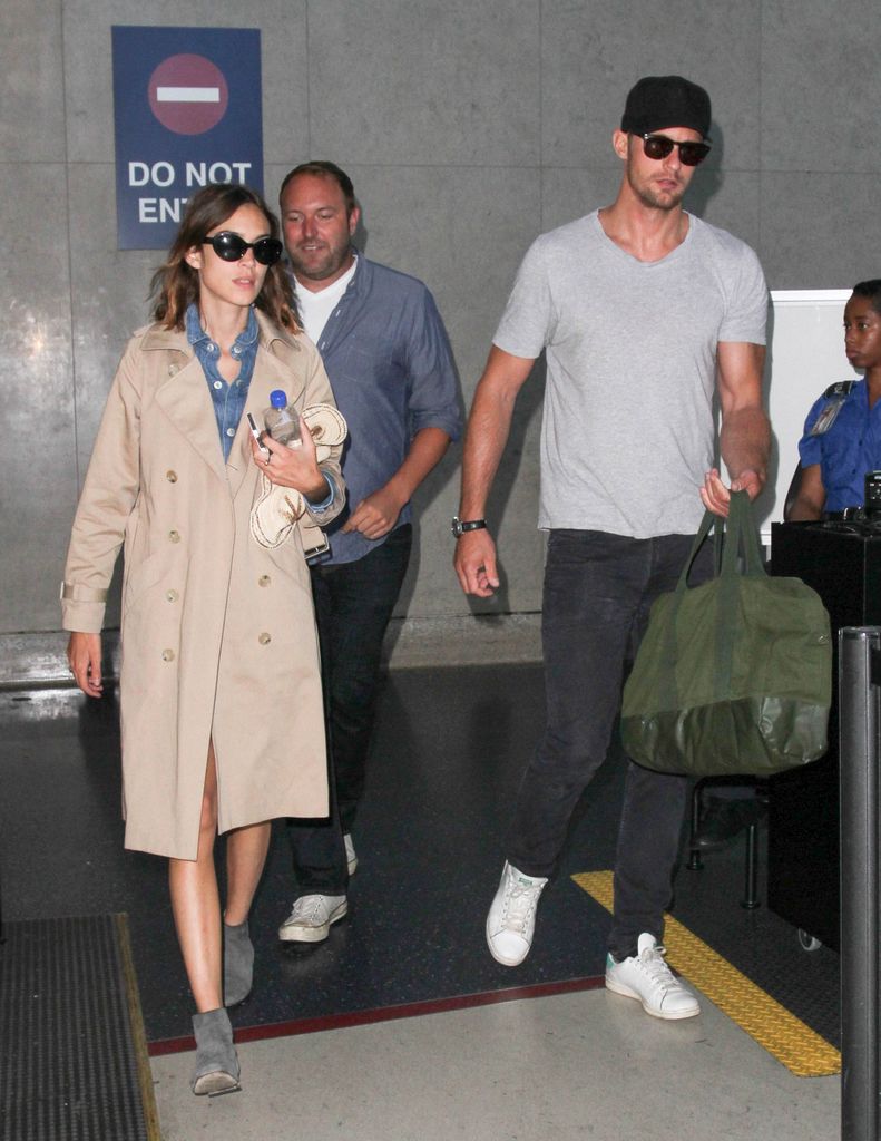 Alexander Skarsgard en t-shirt gris et Alexa Chung en trench-coat sont vus à LAX en 2015