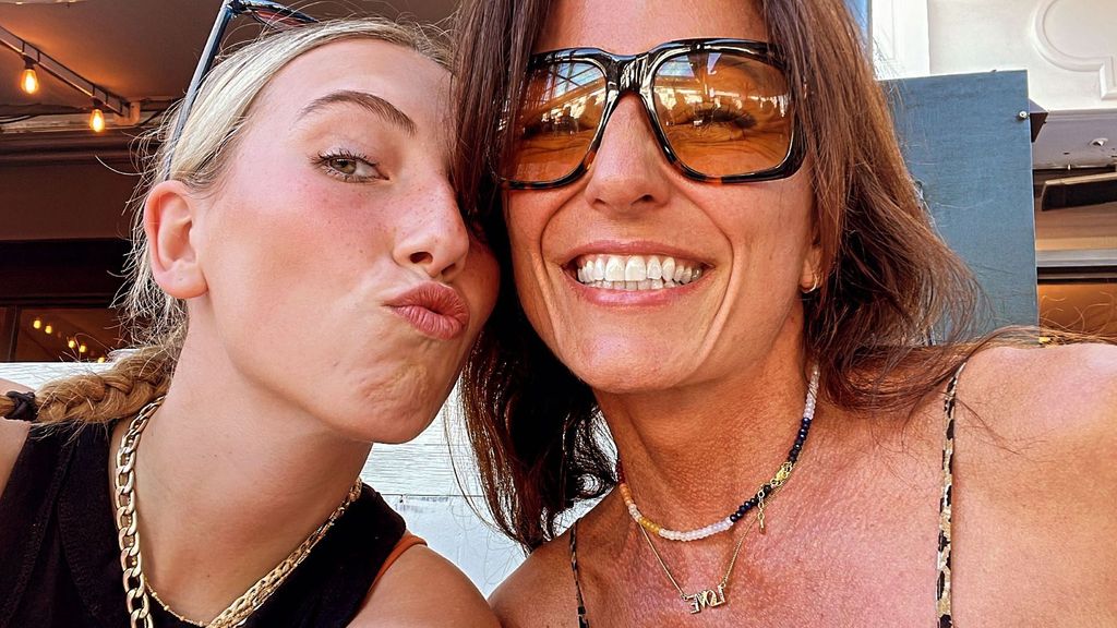 Davina McCal smiles wearing sunglasses as her daughter makes a pout face