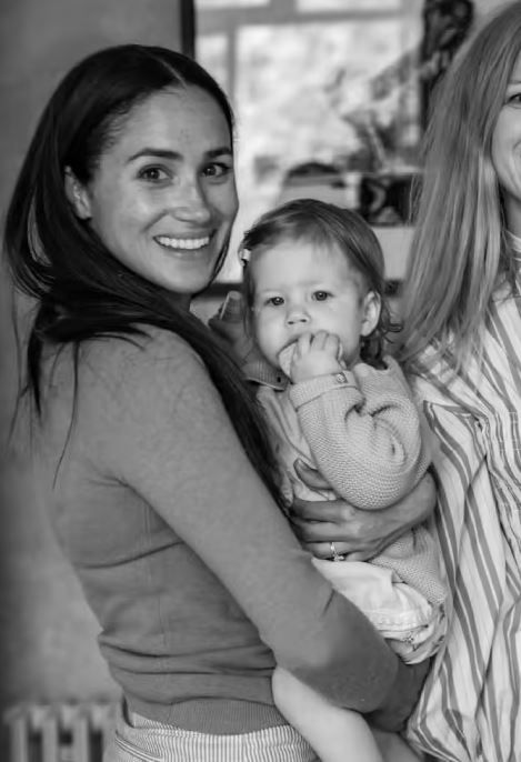 meghan holding lilibet diana and smiling 