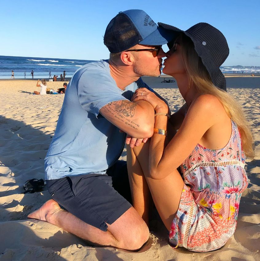 Ronan Keating leaning in two kiss wife Storm on the beach