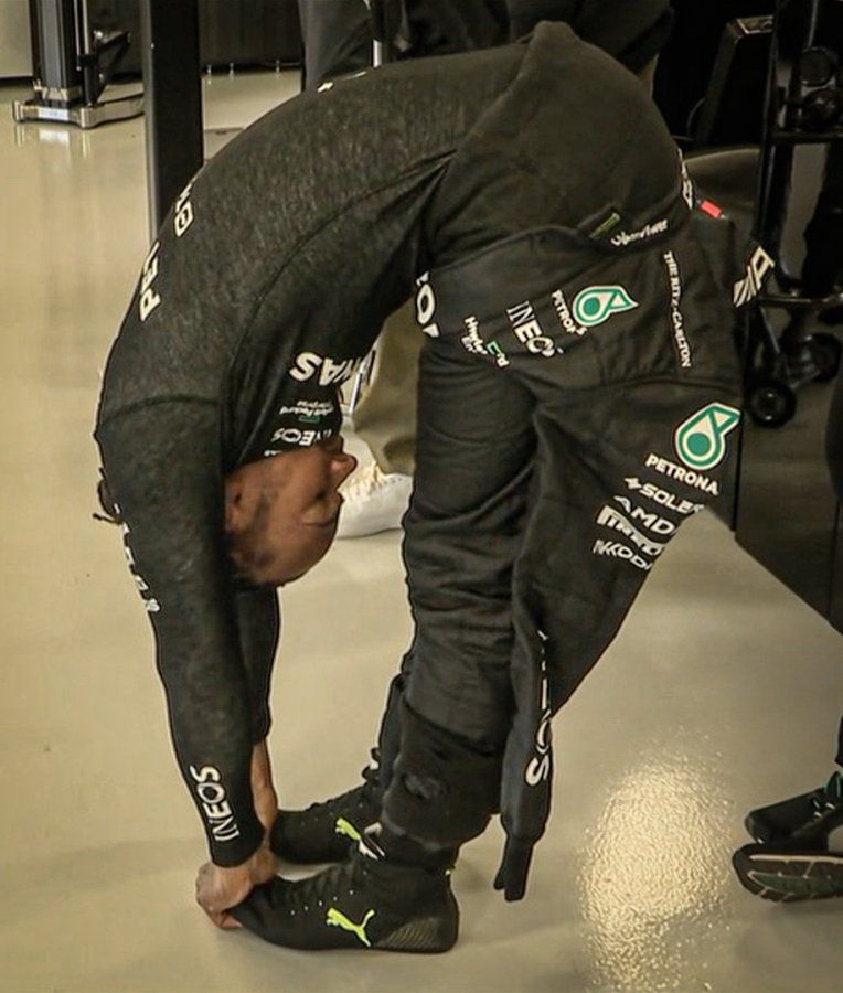 Lewis Hamilton stretching to touch his toes