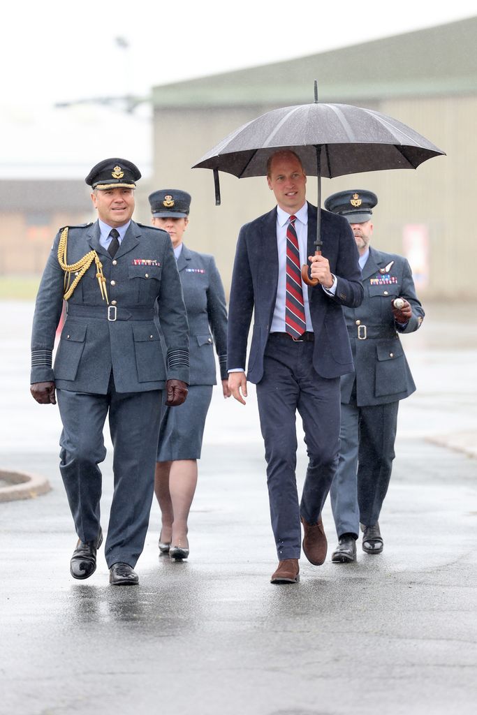 prince william walking in rain with umbrella