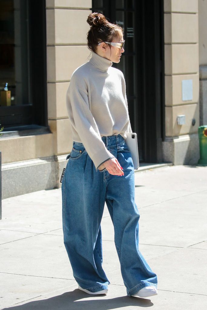 Jennifer Lopez wearing a white jumper and blue jeans