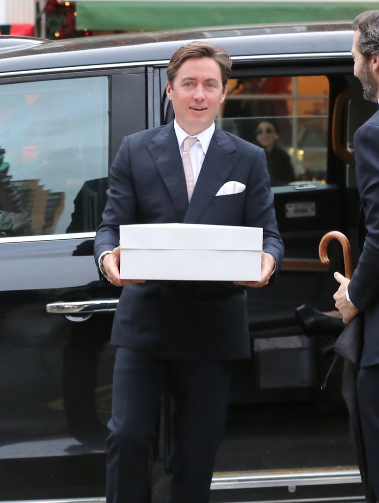 Edoardo Mapelli Mozzi holding a cake box after Athena's christening