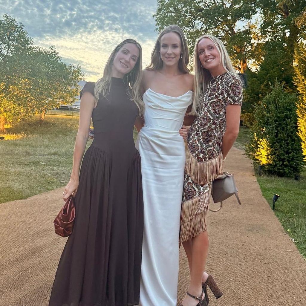 Hum in bridal gown between two friends