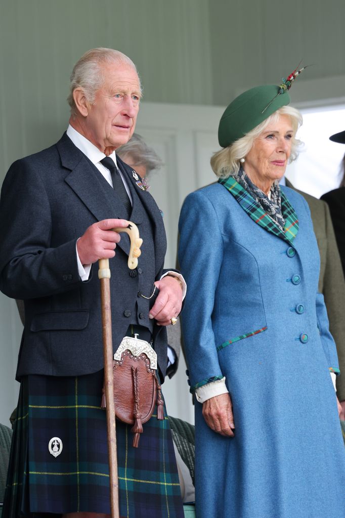 King Charles and Queen Camilla looking solemn