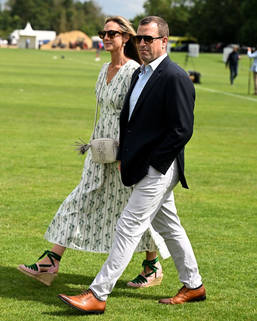 Harriet Sperling and Peter Phillips walk across polo field