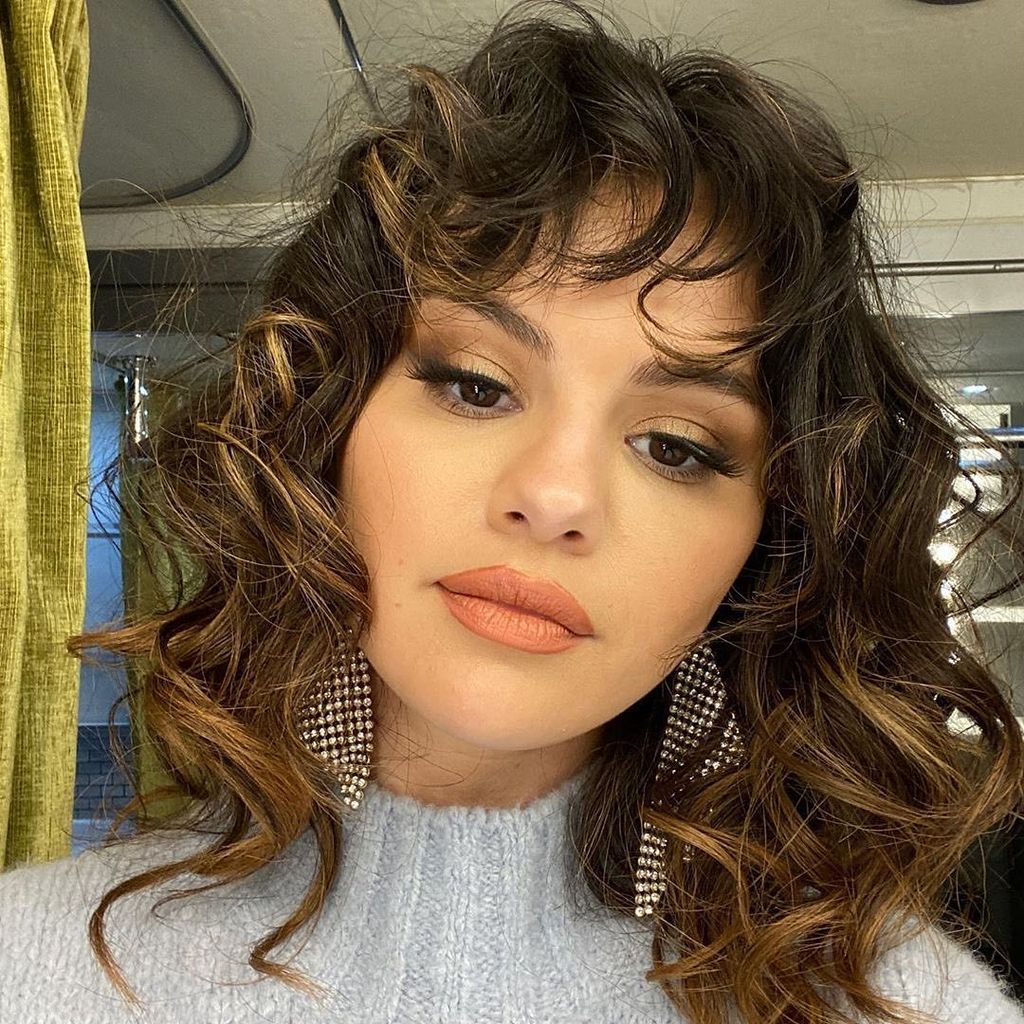 selena gomez layered long midi curly hair cut with bangs
