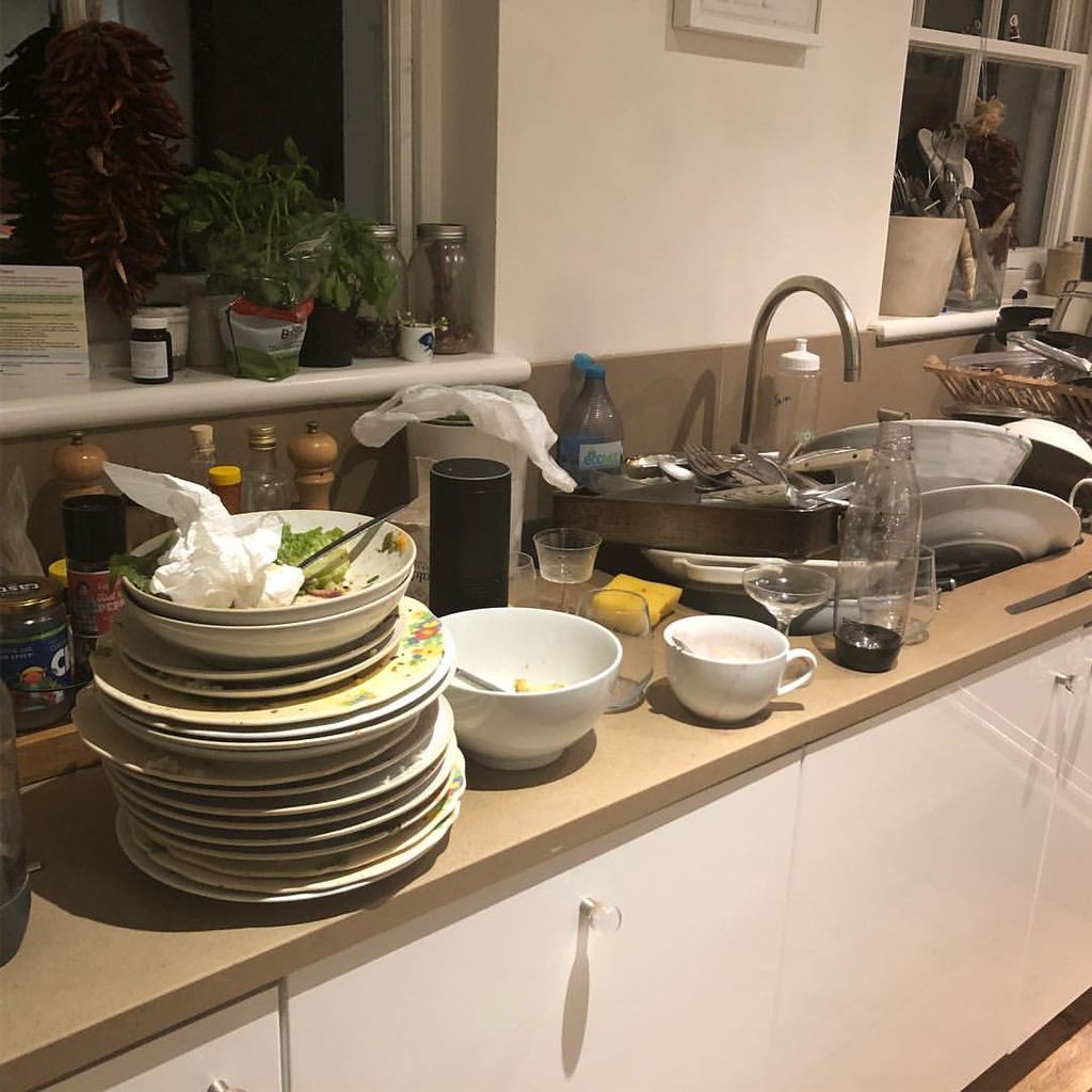 Photo shared by Jason Isaacs of his kitchen surfaces at home covered in stacks plates and crockery