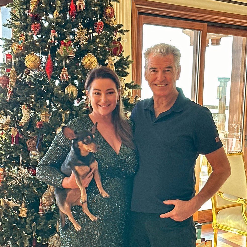 Keely and Pierce Brosnan pose in front of Christmas tree 
