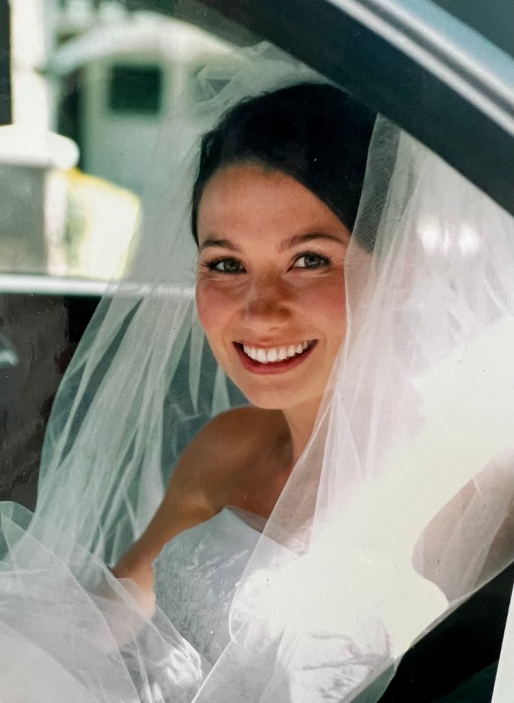 Rosie in car in wedding dress and veil