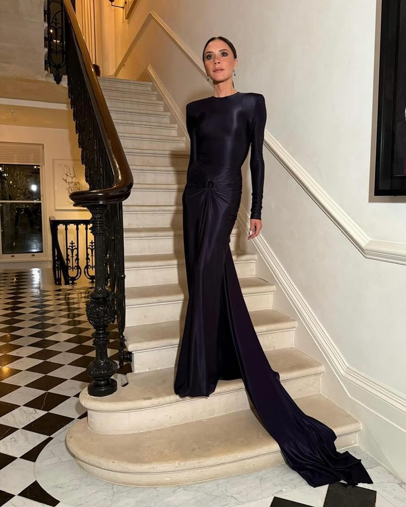 Victoria Beckham usando vestido maxi azul marinho para evento no Palácio de Buckingham