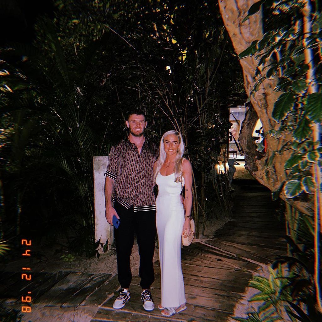 Alex Greenwood in a white dress in a tropical location with her boyfriend Jack O’Connell