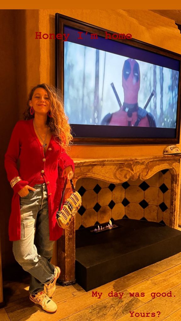 Blake Lively in a cardigan leaning against her fireplace