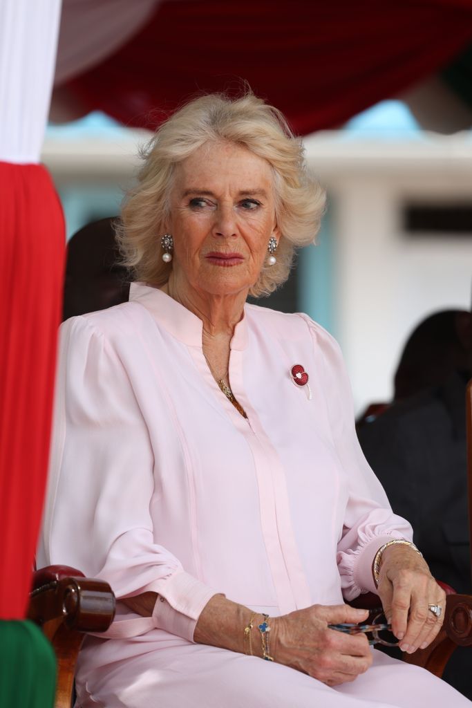 Queen Camilla in a pink dress and pearl earrings