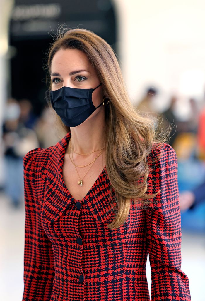 Kate portant un masque noir et une robe rouge en gros plan