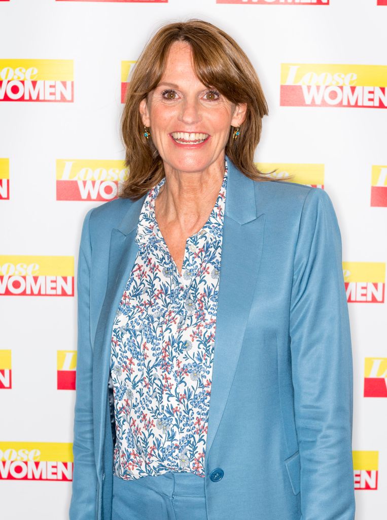 woman posing in powder blue suit and floral shirt