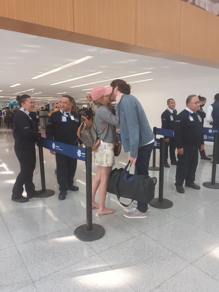 Emma couldn't keep her hands off her new boyfriend, sharing a kiss at the airport