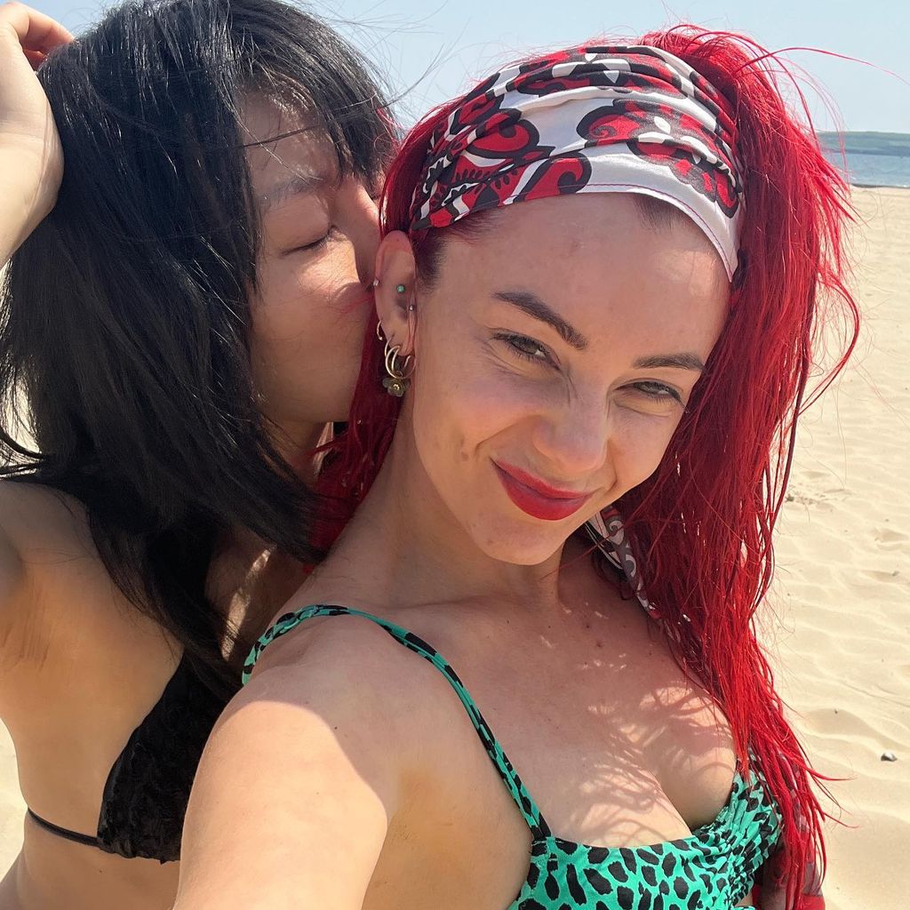 Dianne Buswell is kissed by Nancy Xu as she wears a bold headwrap and animal print bikini from Freya Lingerie