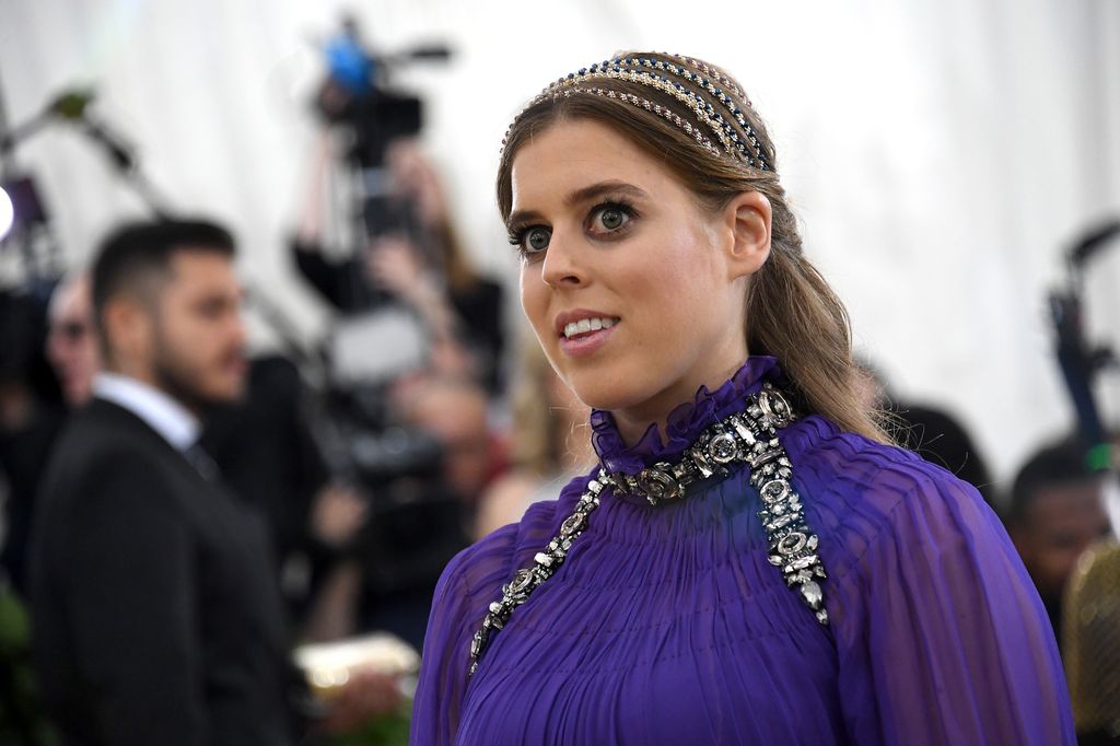 Princess Beatrice at the Met Gala in 2018 wearing a purple dress and headbands