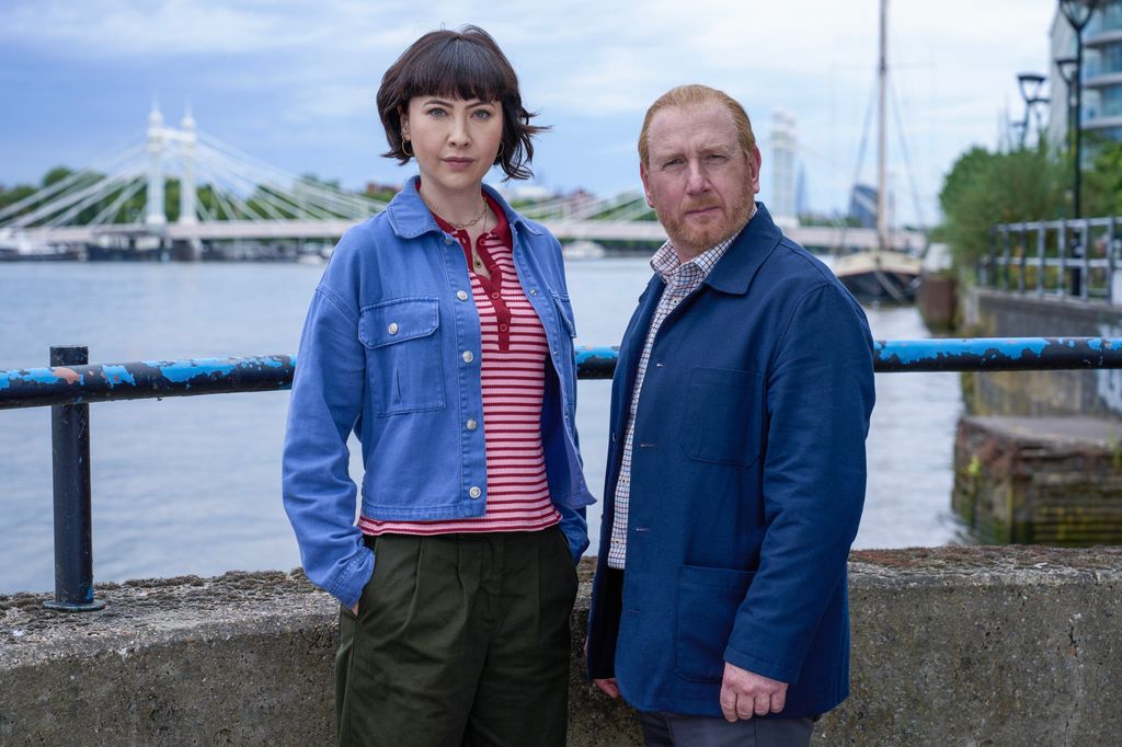 woman with short dark hair standing next to man on bridge 