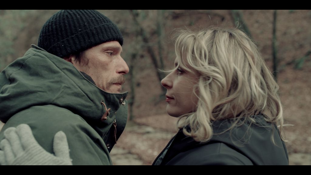 man and woman looking at each other in woods
