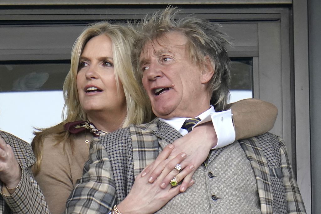 Penny Lancaster hugging Rod Stewart from behind
