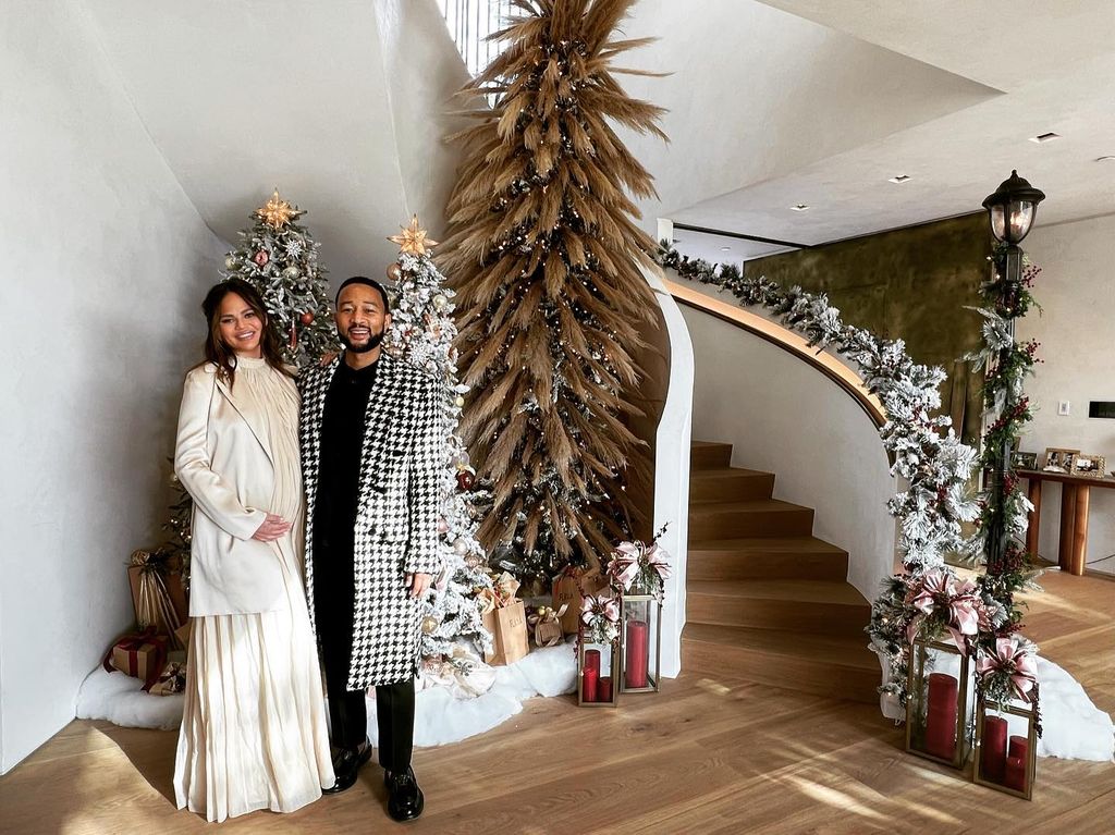 Chrissy and John in their christmas decorated their gold entryway