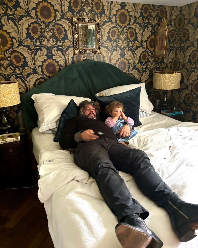 Laurence Llewelyn-Bowen in bedroom at Cotswolds home with grandchild