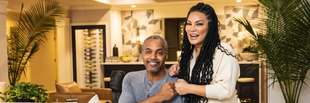 As seen on Married to Real Estate, hosts Mike Jackson and Egypt Sherrod pose for a photo in the newly renovated and designed basement bar 