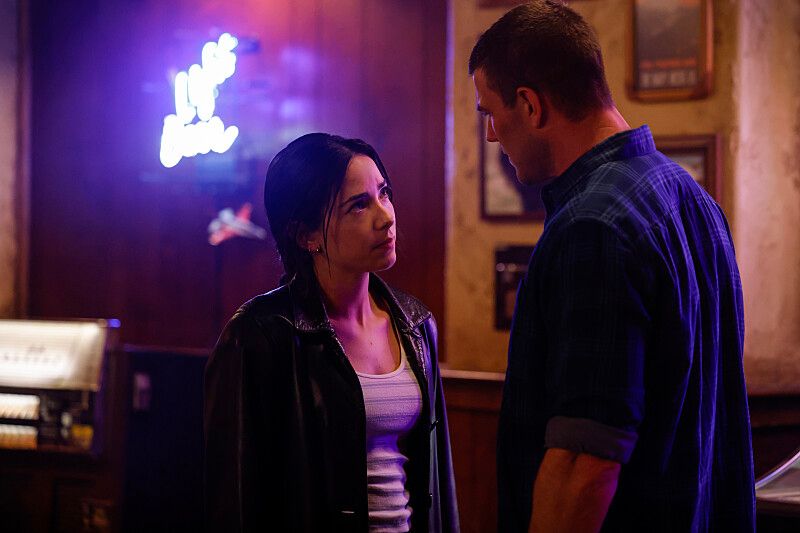 woman and man talking in dimly lit bar