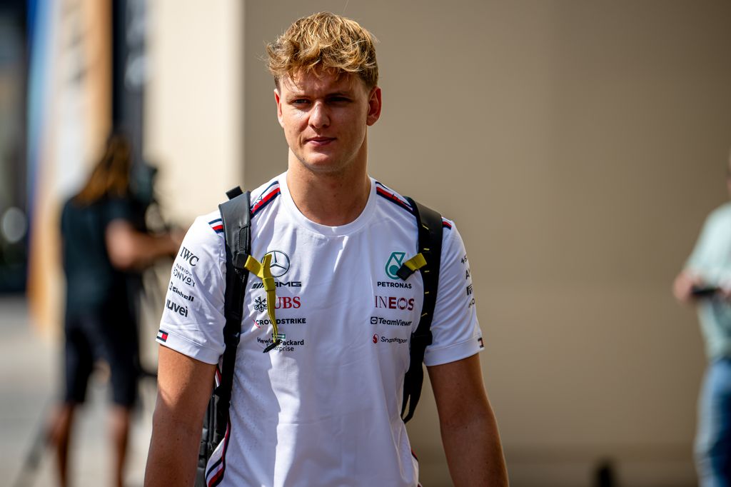 Mick Schumacher walking a white shirt