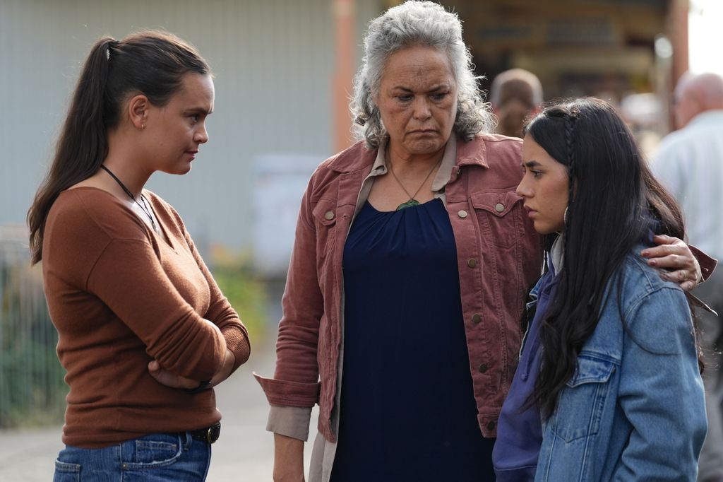 three women standing in street