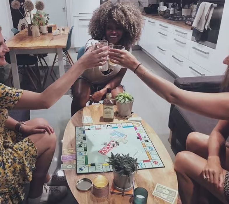 fleur east cheersing with friends in kitchen