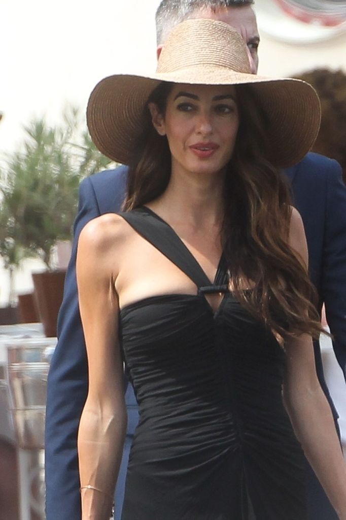 �Amal Clooney wore a beautiful black bodycon dress and wide-brimmed straw hat